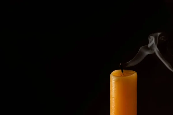 Church extinguished candle on dark background, closeup. Space for text