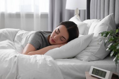 Evdeki yumuşak yatakta uyuyan güzel bir genç kadın.