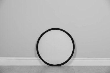 Stüdyo yansıtıcısı odada gri duvarın yanında. Profesyonel fotoğrafçı ekipmanı.