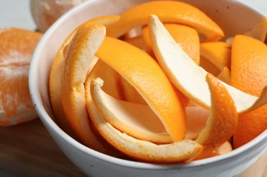 Orange zest preparing for drying and fresh fruits on wooden table, closeup