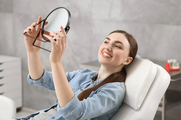 Ung Kvinna Tittar Sina Nya Tandimplantat Spegeln Inomhus — Stockfoto