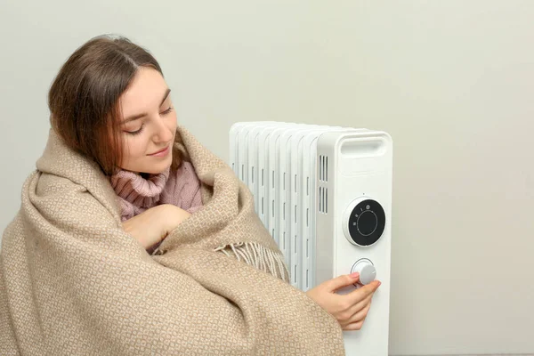 Young Woman Adjusting Temperature Modern Electric Heater Beige Wall — Stock Photo, Image