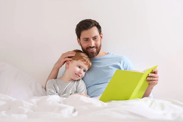 Father Reading Book His Child Bed Home — Stockfoto