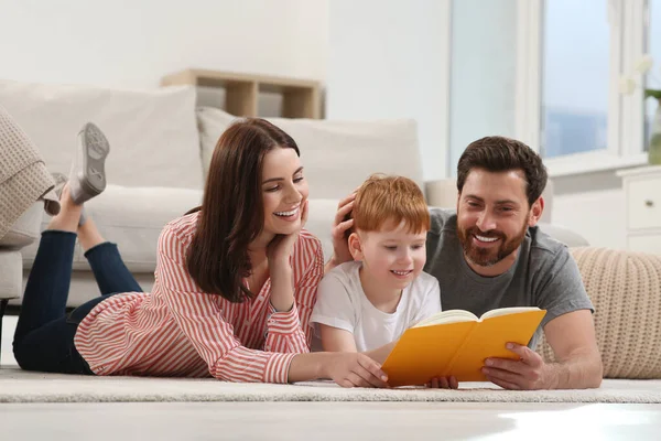 Gelukkige Ouders Met Hun Kind Lezen Boek Vloer Thuis — Stockfoto