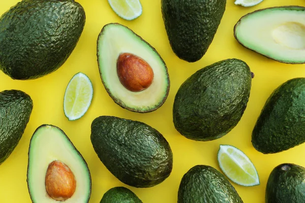Veel Vers Geheel Gesneden Avocado Met Limoenen Gele Achtergrond Plat — Stockfoto
