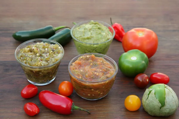 stock image Tasty salsa sauces and ingredients on wooden table