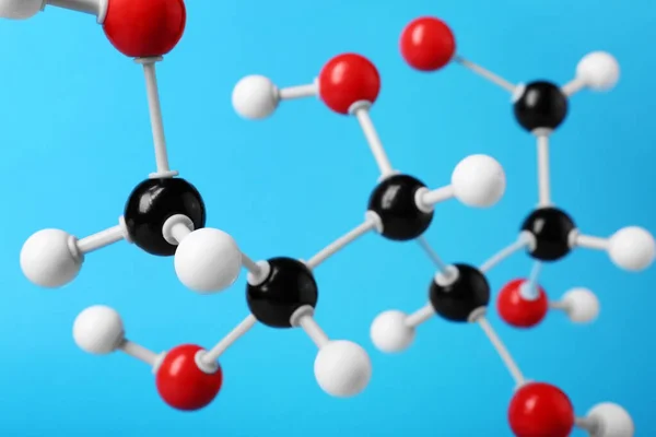 Molecule of glucose on light blue background, closeup. Chemical model