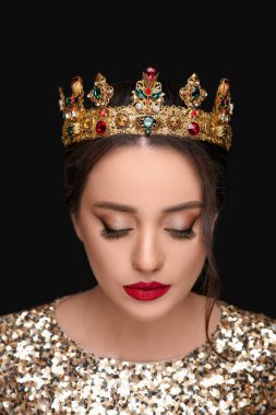 Siyah arka planda lüks bir taç giyen güzel bir genç kadın.