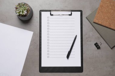 Üzerinde karton kutular olan pano, gri masa üzerinde bitki ve ofis kağıtları, düz yatak. Kontrol Listesi