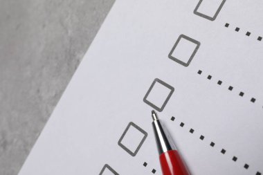 Kağıt kağıtlar, işaretli kutular ve açık gri masa üzerinde kalem, yakın plan. Kontrol Listesi