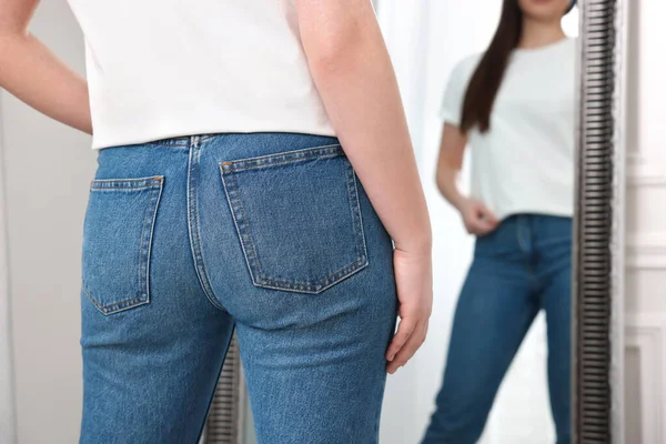 鏡の近くのスタイリッシュなジーンズの女性屋内 クローズアップ — ストック写真