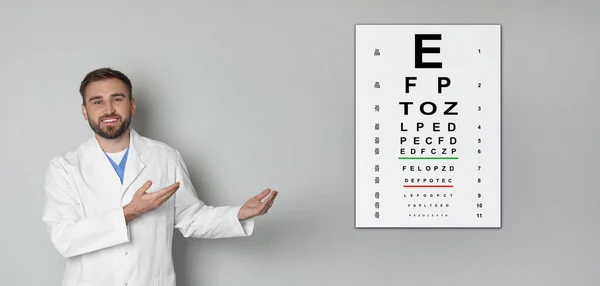 Teste Visão Oftalmologista Optometrista Apontando Para Gráfico Olho Parede Cinza — Fotografia de Stock