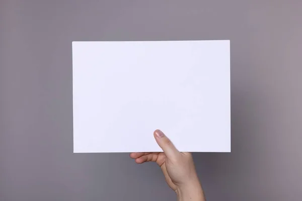 Woman Holding Sheet Paper Grey Background Closeup Mockup Design — Stock Fotó