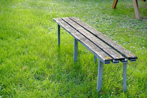 屋外の緑の芝生の上で木製のベンチ テキストのスペース — ストック写真