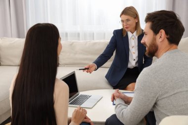 Real estate agent consulting couple in new apartment