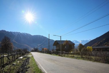 Güneşli bir günde dağlardaki boş asfalt karayolu manzarası. Yolculuk