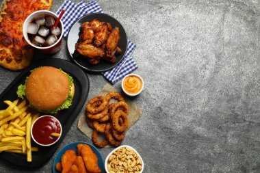 Patates kızartması, hamburger ve diğer fast food gri dokuma masasında, düz bir şekilde uzanıyordu.