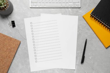 Kağıt kağıtlar, karton kutular, bitki ve bilgisayar klavyesi, açık gri mermer masa, düz konum. Kontrol Listesi