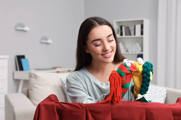 Happy woman performing puppet show at home
