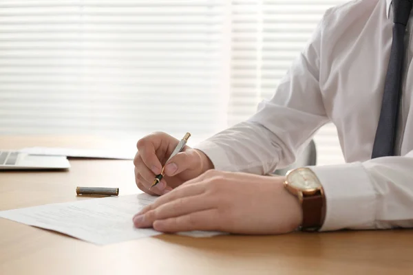 stock image Notary signing document at wooden table in office, closeup