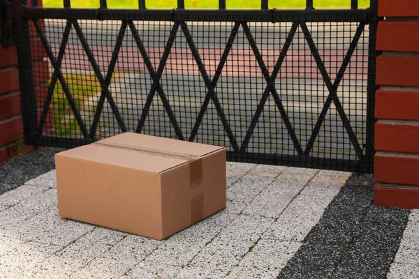 Cardboard boxes near front gates outdoors. Parcel delivery service