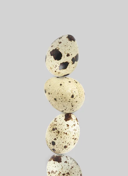 ライトグレーの背景にスタッキングされたうずらの卵 — ストック写真