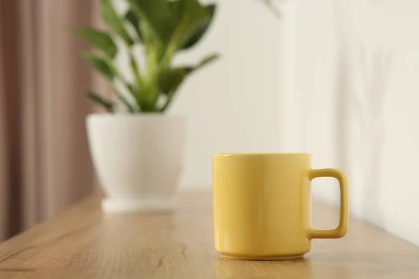 木制桌子上的黄色杯子在室内 用于设计的模型 — 图库照片