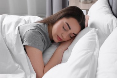 Evdeki yumuşak yatakta uyuyan güzel bir genç kadın.