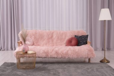 Comfortable sofa, floor lamp and coffee table in stylish room. Interior design