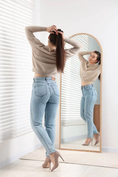 Jovem Mulher Jeans Elegantes Perto Espelho Dentro Casa — Fotografia de Stock