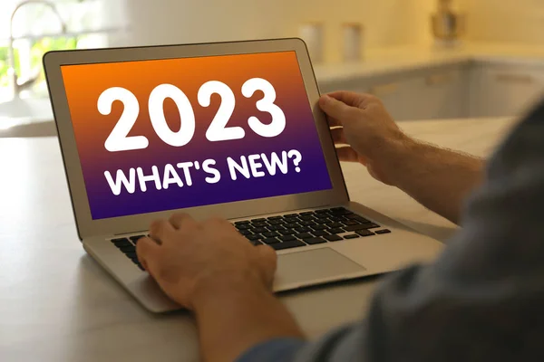 Future trends. 2023 What's New? text on laptop display. Man using device, closeup