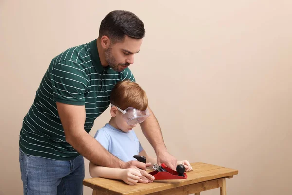 Ojciec Uczy Syna Jak Pracować Samolotem Przy Beżowej Ścianie — Zdjęcie stockowe