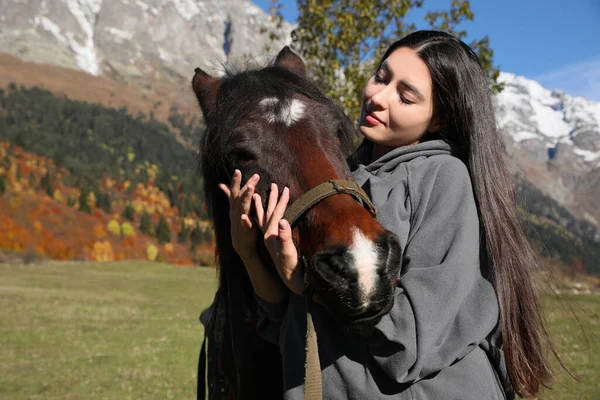 晴れた日には若い女性が山の中で馬を抱いている 美しいペット — ストック写真
