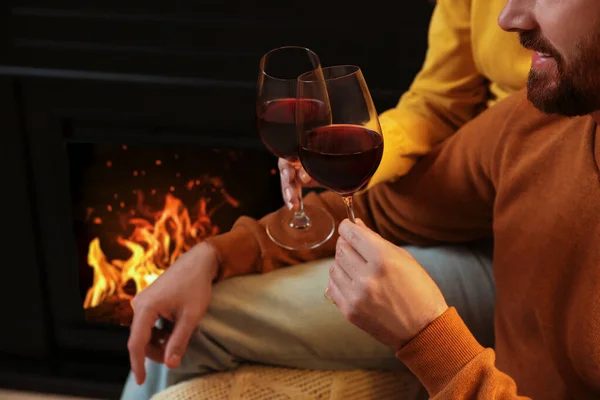 可爱的一对情侣 带着酒杯 在家里壁炉边亲密地呆在一起 — 图库照片