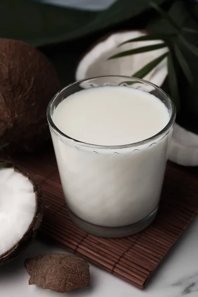 Glas Leckere Vegane Milch Kokosnussstücke Und Palmblätter Auf Weißem Marmortisch — Stockfoto