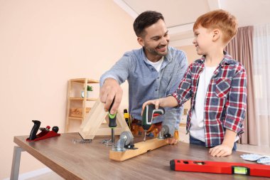 Baba ve oğul, tekerlekleri odundan oduna çeviriyor. Onarım işi