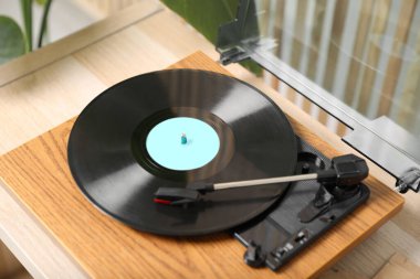 İçerideki açık ahşap masada üzerinde vinil disk olan şık bir pikabın var.