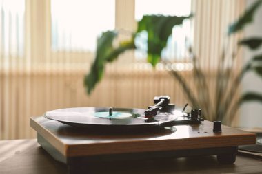 İçerideki ahşap masa üzerinde vinil disk olan şık bir döner tabla, metin için yer