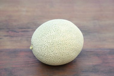 Whole ripe cantaloupe melon on wooden table