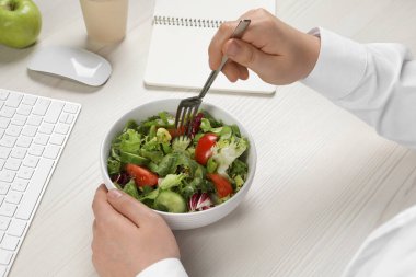 Ofis çalışanı iş yerinde öğle yemeği yiyor, yakın plan.