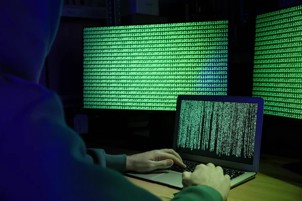 黑客在室内木制桌旁与电脑一起工作 特写镜头 网络攻击 — 图库照片