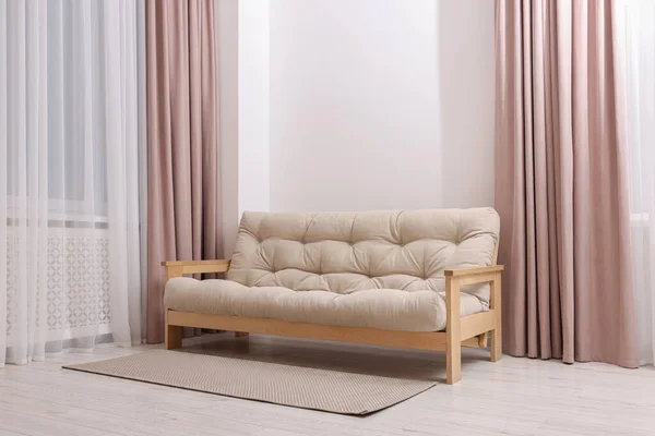 Comfortable sofa with rug in cozy light room. Interior design