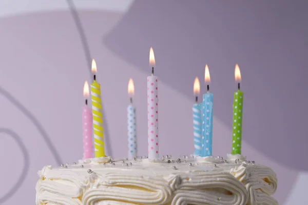 Läcker Tårta Med Grädde Brinnande Ljus Färg Bakgrund Närbild — Stockfoto