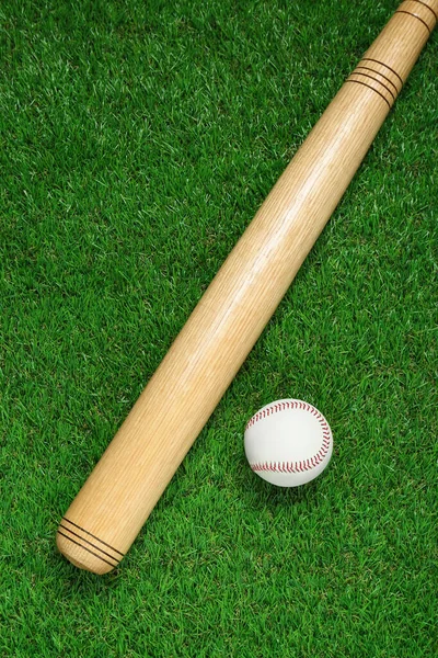 木制棒球棒和绿色草地上的球 平躺在地上 体育设备 — 图库照片