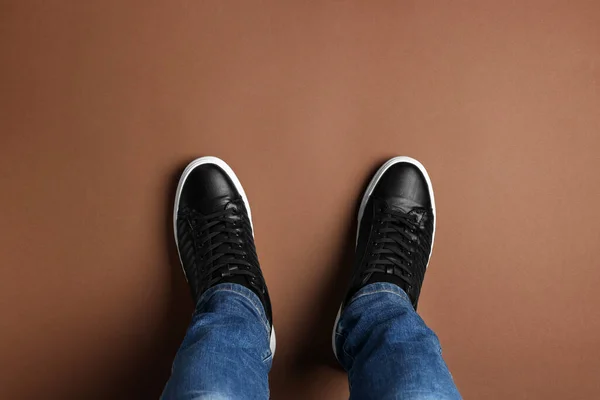 Man Stylish Sneakers Standing Brown Background Top View — Stock Photo, Image