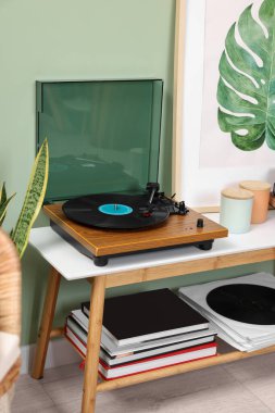 İçerideki konsol masasında vinil plaklı şık bir pikap.