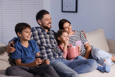 Mutlu aile akşamları evde televizyon seyrediyor.
