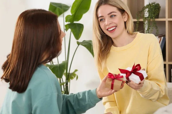Улыбающиеся Молодые Женщины Дарящие Друг Другу Подарки Помещении — стоковое фото