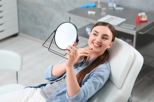Ung Kvinna Tittar Sina Nya Tandimplantat Spegeln Inomhus — Stockfoto