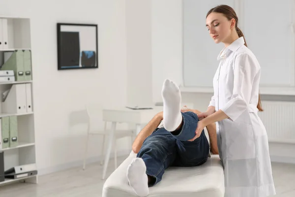 在诊所检查病人腿的专业矫形师 — 图库照片